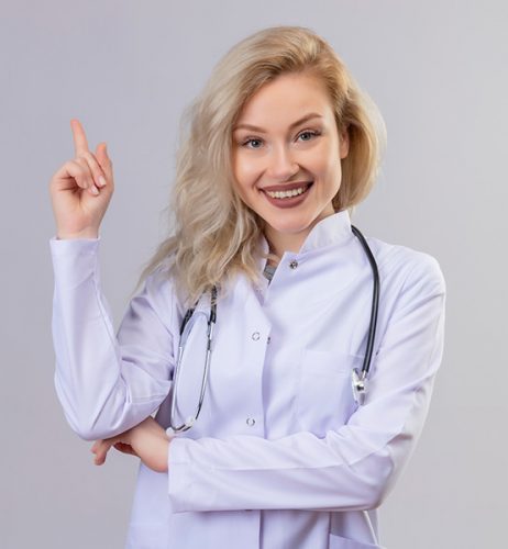smiling-young-doctor-wearing-stethoscope-medical-gown-points-side-white-wall